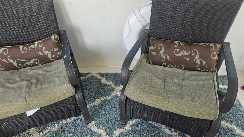 Elusive Yacht Photos Pics Two wicker chairs with patterned cushions on a yacht's deck, Carver 500 Cockpit Motor Yacht, 1997.