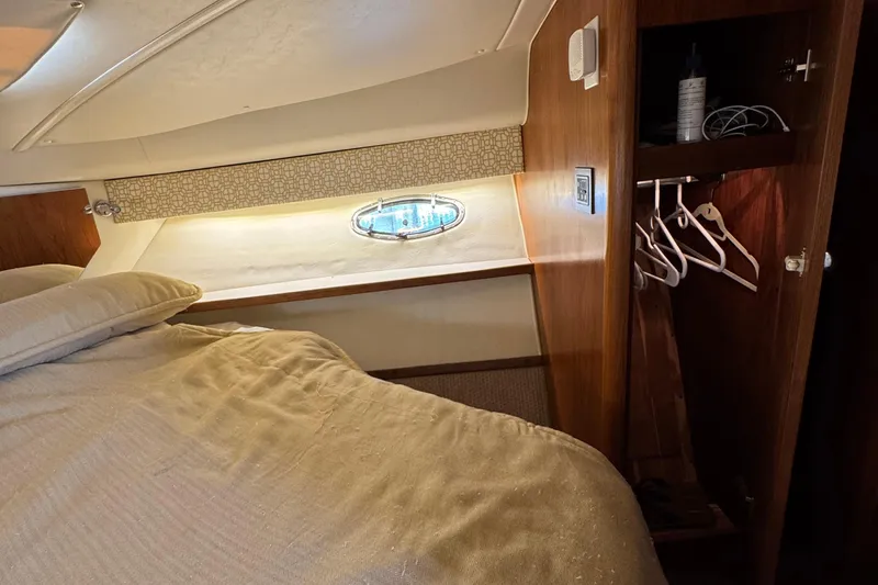 Dark And Stormy Yacht Photos Pics Interior cabin of 2000 Tiara Yachts 3500 Express with bed, porthole, and closet.