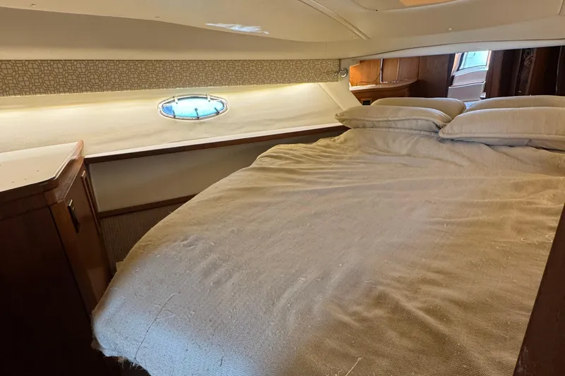 Dark And Stormy Yacht Photos Pics Cozy cabin interior of 2000 Tiara Yachts 3500 Express with bed and porthole.