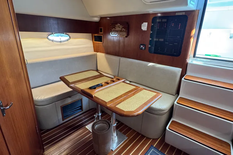 Dark And Stormy Yacht Photos Pics Interior of 2000 Tiara Yachts 3500 Express with wooden table and seating area.