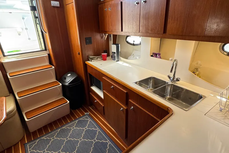 Dark And Stormy Yacht Photos Pics Interior of 2000 Tiara Yachts 3500 Express, featuring a wooden kitchen with dual sinks.