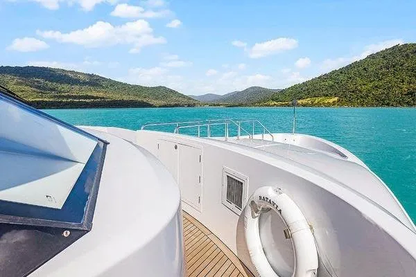 Batavia Yacht Photos Pics Richmond Yachts 135 Motor Yacht cruising on turquoise waters, surrounded by lush hills.