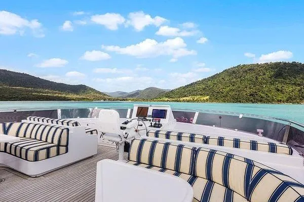 Batavia Yacht Photos Pics Luxurious Richmond Yachts 135 Motor Yacht deck with striped seating, scenic water and mountain views.