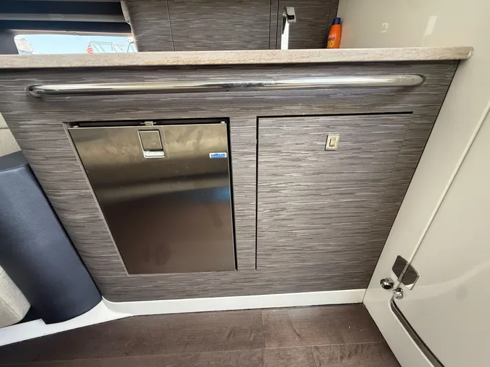  Yacht Photos Pics 2017 Boston Whaler 420 Outrage interior with compact fridge and sleek cabinetry.