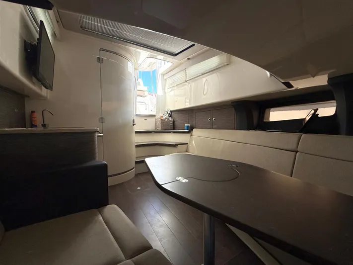  Yacht Photos Pics Interior of 2017 Boston Whaler 420 Outrage, featuring a modern cabin with seating and table.