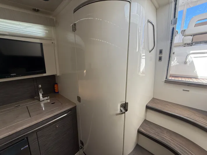  Yacht Photos Pics 2017 Boston Whaler 420 Outrage interior with kitchenette, TV, and stairs to deck.