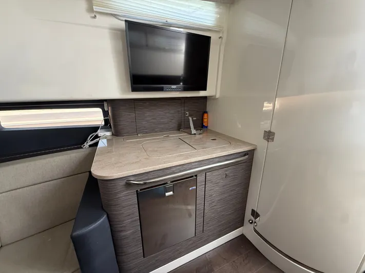  Yacht Photos Pics Interior of a 2017 Boston Whaler 420 Outrage featuring a compact kitchenette and TV.