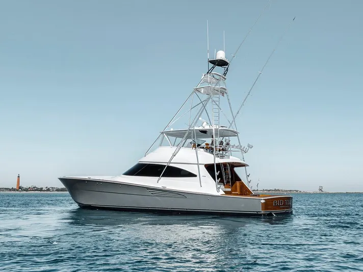 Bid Time Yacht Photos Pics 2023 Viking 72 Convertible yacht on calm water, showcasing sleek design and luxury features.