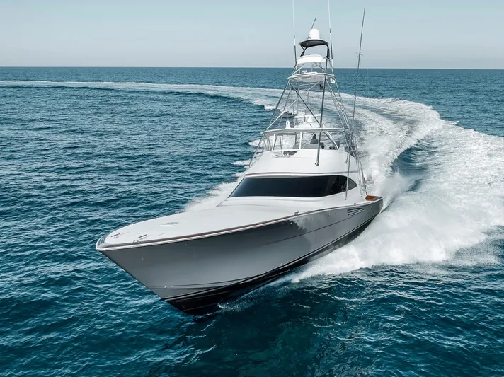 Bid Time Yacht Photos Pics 2023 Viking 72 Convertible yacht cruising swiftly on open ocean waters.
