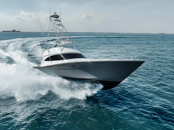 Bid Time Yacht Photos Pics 2023 Viking 72 Convertible yacht cruising swiftly on open ocean waters.