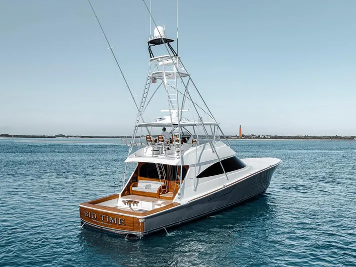 Bid Time Yacht Photos Pics 2023 Viking 72 Convertible yacht on calm blue waters, showcasing sleek design and luxury features.