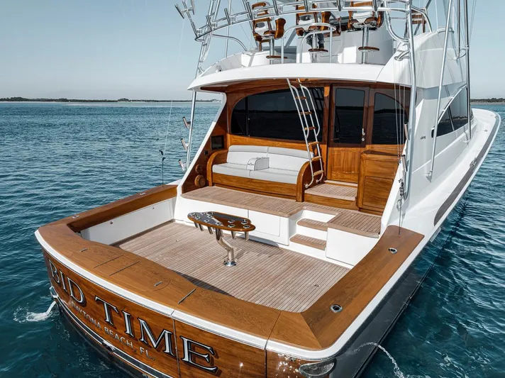 Bid Time Yacht Photos Pics 2023 Viking 72 Convertible yacht on water, featuring spacious deck and elegant wood finish.