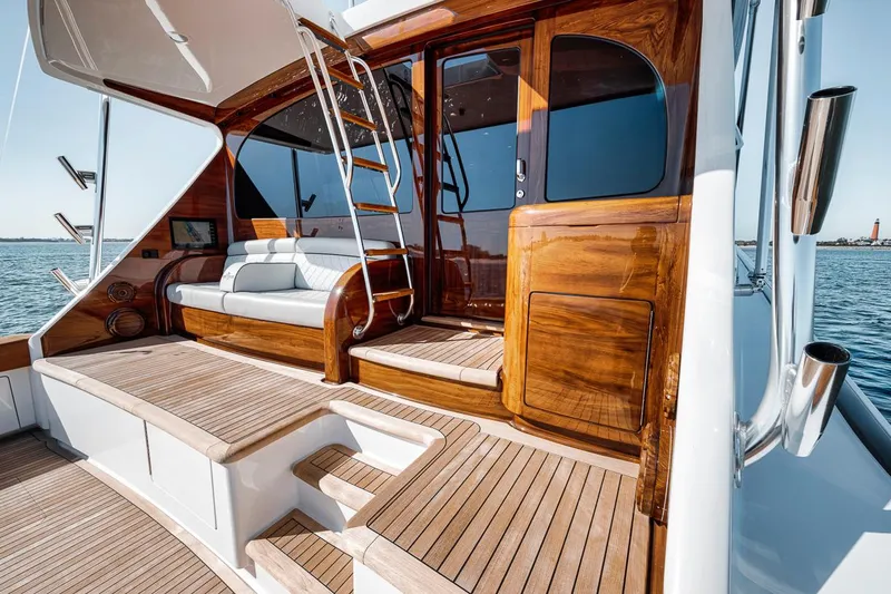 Bid Time Yacht Photos Pics 2023 Viking 72 Convertible yacht with elegant wooden deck and seating area.