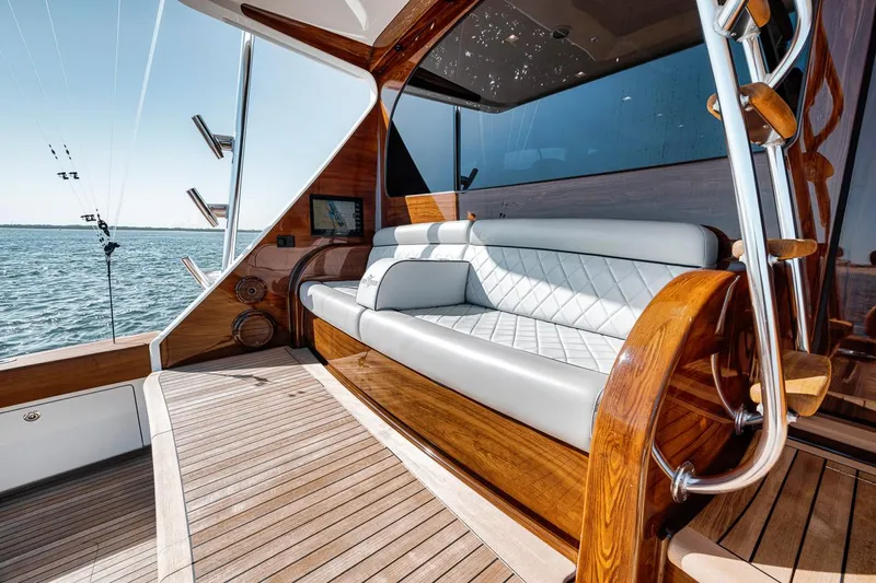 Bid Time Yacht Photos Pics Luxurious seating area on 2023 Viking 72 Convertible yacht with elegant wood and leather finishes.