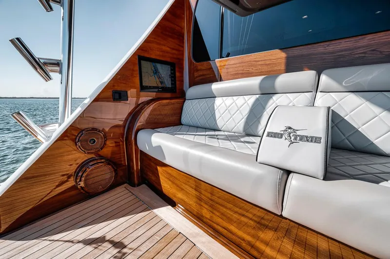 Bid Time Yacht Photos Pics Luxurious seating area on 2023 Viking 72 Convertible yacht with elegant wood finish.