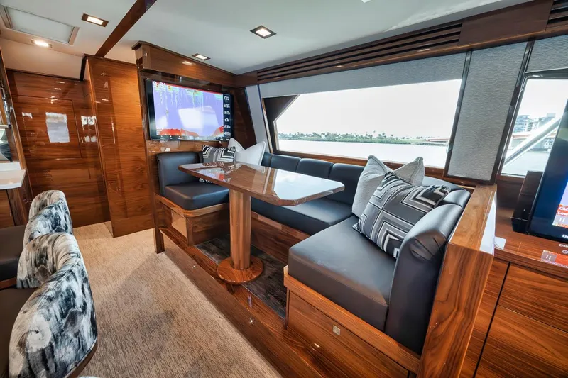 Bid Time Yacht Photos Pics Luxurious interior of 2023 Viking 72 Convertible yacht with elegant seating and wooden finishes.
