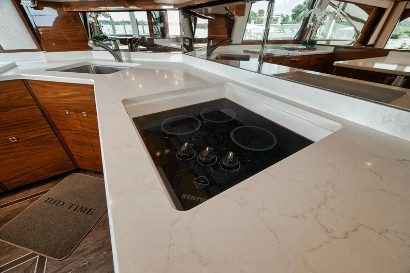 Bid Time Yacht Photos Pics Modern kitchen in 2023 Viking 72 Convertible yacht with sleek countertops and stove.