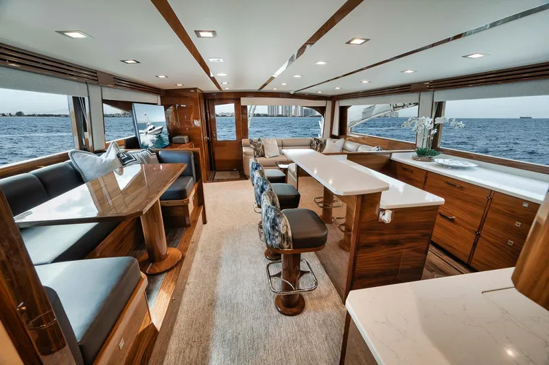 Bid Time Yacht Photos Pics Luxurious interior of 2023 Viking 72 Convertible yacht with elegant seating and ocean view.