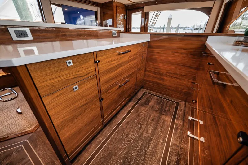 Bid Time Yacht Photos Pics Luxurious interior of 2023 Viking 72 Convertible yacht with elegant wood cabinetry.