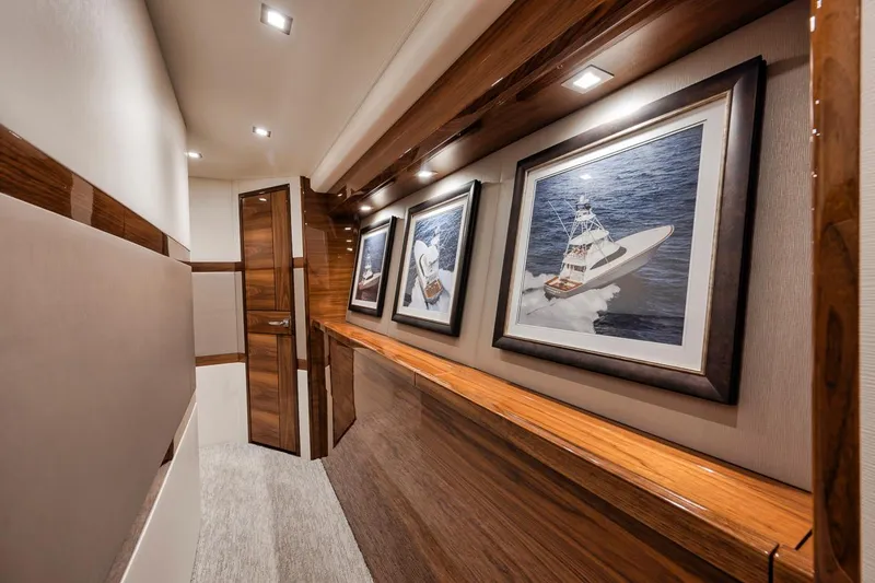 Bid Time Yacht Photos Pics Interior hallway of 2023 Viking 72 Convertible yacht with framed boat artwork.