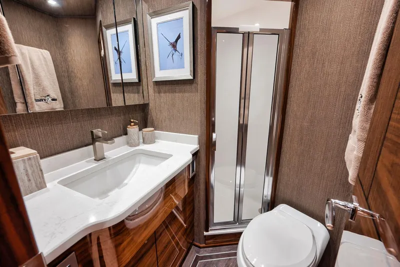 Bid Time Yacht Photos Pics Luxurious bathroom in 2023 Viking 72 Convertible yacht with modern fixtures and elegant decor.