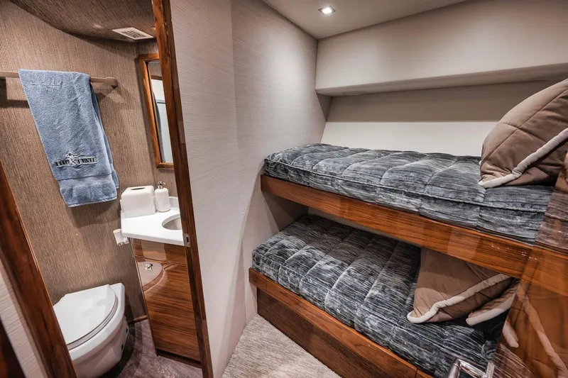 Bid Time Yacht Photos Pics 2023 Viking 72 Convertible yacht interior with bunk beds and bathroom.