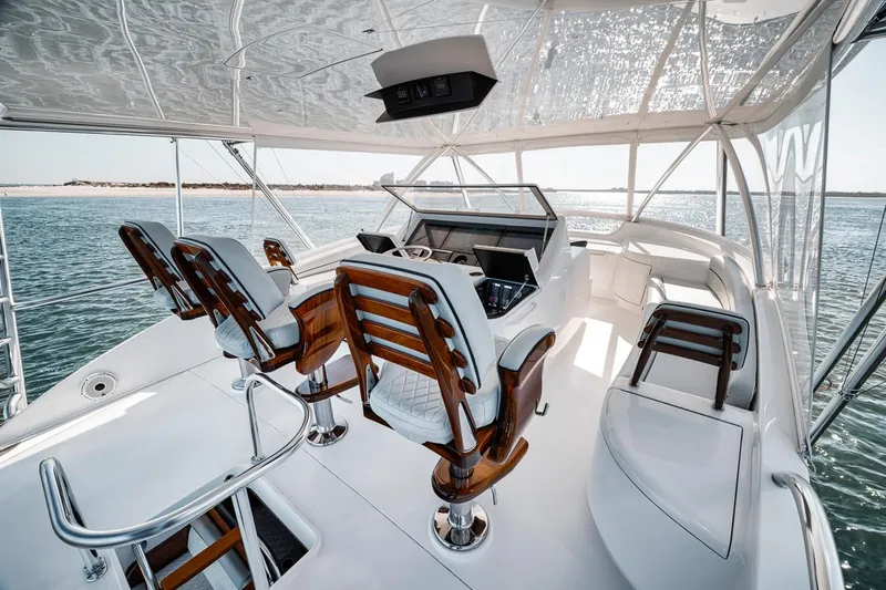 Bid Time Yacht Photos Pics 2023 Viking 72 Convertible yacht interior with luxurious seating and ocean view.