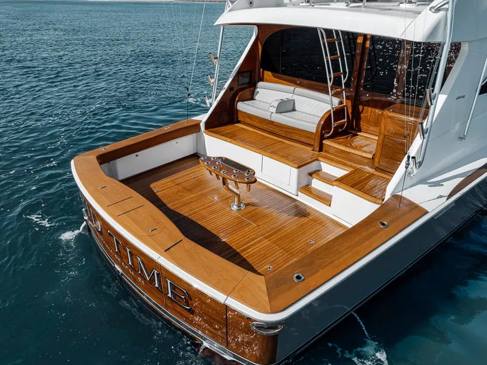 Bid Time Yacht Photos Pics 2023 Viking 72 Convertible yacht with wooden deck on calm ocean waters.