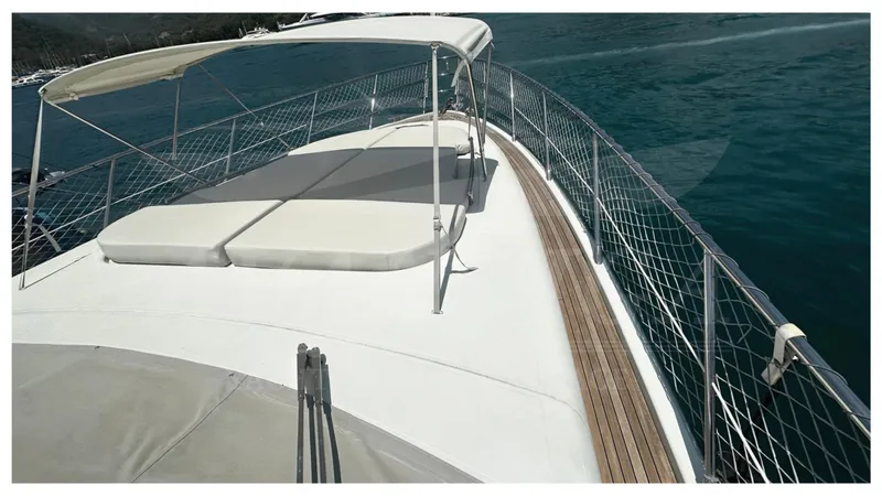  Yacht Photos Pics 2009 Azimut 68S yacht deck with sunbathing area and safety railings on the water.