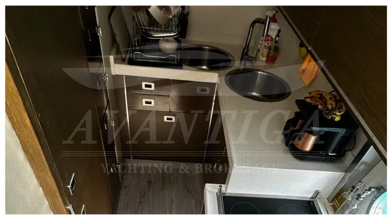  Yacht Photos Pics Compact kitchen area in a 2009 Azimut 68S yacht, featuring modern appliances and storage.