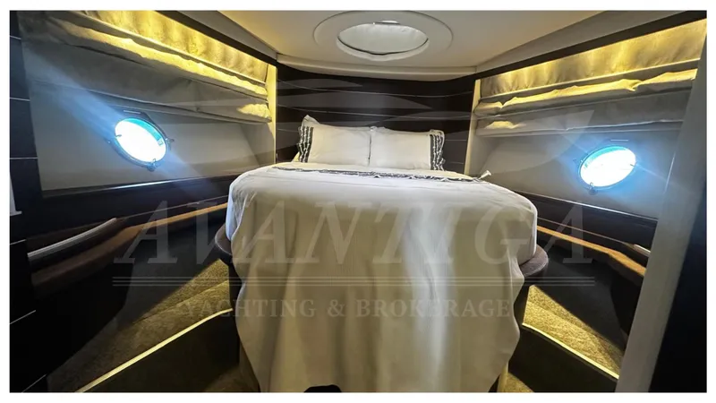  Yacht Photos Pics Luxurious bedroom interior of 2009 Azimut 68S yacht with porthole windows and elegant bedding.