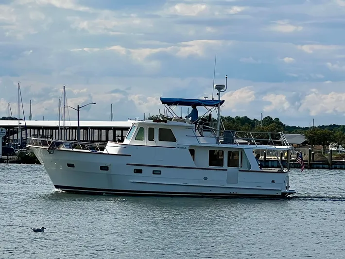 Xanadu Yacht Photos Pics 2006 DeFever Pilothouse yacht cruising on a calm waterway under a cloudy sky.