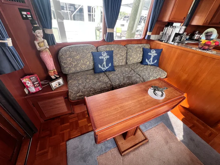 Xanadu Yacht Photos Pics 2006 DeFever Pilothouse interior with nautical decor, wooden table, and patterned sofa.