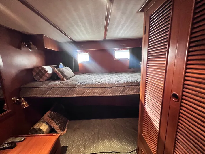 Xanadu Yacht Photos Pics Cozy cabin interior of 2006 DeFever Pilothouse with bed and wooden furnishings.