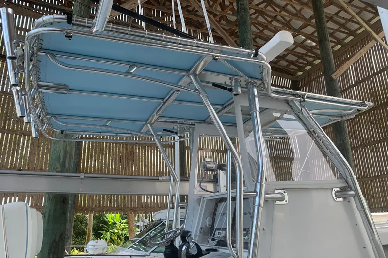  Yacht Photos Pics 2008 Invincible 36 CC boat with blue T-top and stainless steel frame in a boathouse.