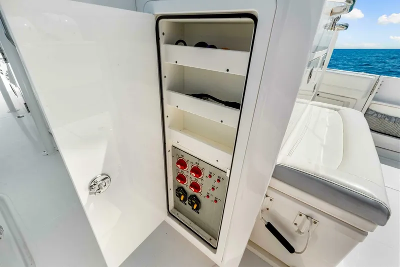  Yacht Photos Pics Open storage compartment on 2021 Nor-Tech 390 SS boat, featuring shelves and control panel.