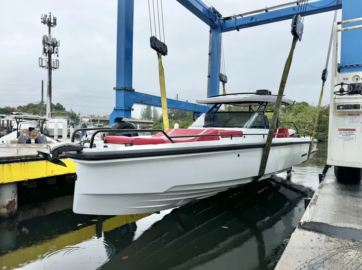 Kraken Yacht Photos Pics 2023 BRABUS Shadow 900 boat being lifted by a crane at a dock.