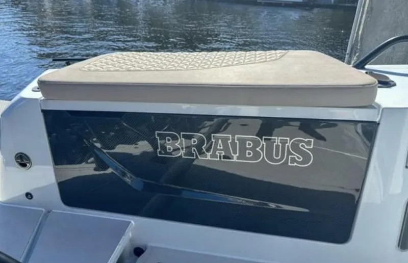 Kraken Yacht Photos Pics 2023 BRABUS Shadow 900 boat with cushioned seating, docked by the water.