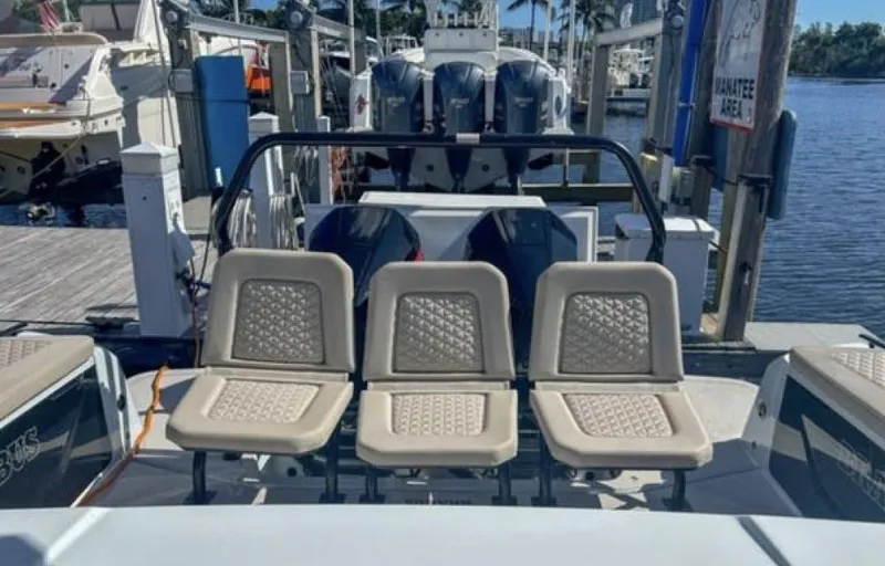 Kraken Yacht Photos Pics 2023 BRABUS Shadow 900 boat with three beige seats at a marina.