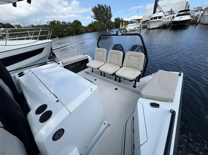 Kraken Yacht Photos Pics 2023 BRABUS Shadow 900 ST boat with sleek seating, docked near other yachts.