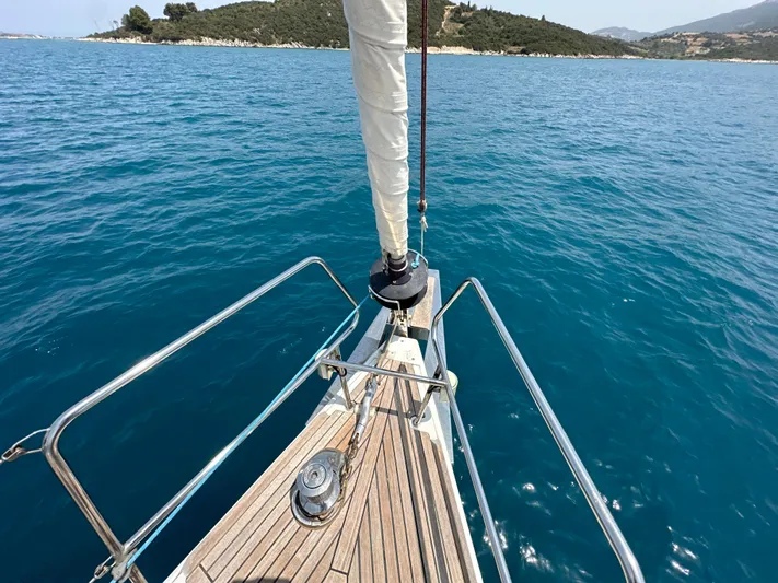 Nick Of Time III Yacht Photos Pics Bow of 2015 Beneteau Oceanis 55 sailboat on clear blue water.