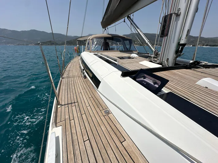 Nick Of Time III Yacht Photos Pics 2015 Beneteau Oceanis 55 sailboat on calm blue waters, showcasing sleek deck design.