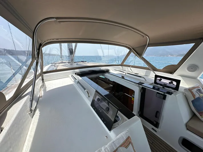 Nick Of Time III Yacht Photos Pics 2015 Beneteau Oceanis 55 cockpit with canopy, overlooking serene ocean waters.