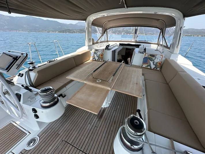 Nick Of Time III Yacht Photos Pics 2015 Beneteau Oceanis 55 yacht cockpit with seating, table, and ocean view.