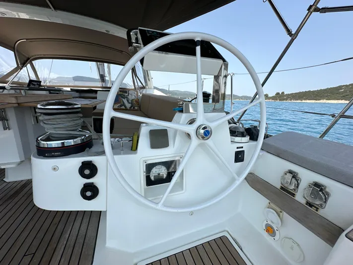 Nick Of Time III Yacht Photos Pics Steering wheel of a 2015 Beneteau Oceanis 55 sailboat on open water.
