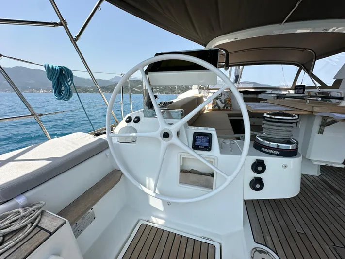 Nick Of Time III Yacht Photos Pics Cockpit of 2015 Beneteau Oceanis 55 sailboat with steering wheel and navigation equipment.