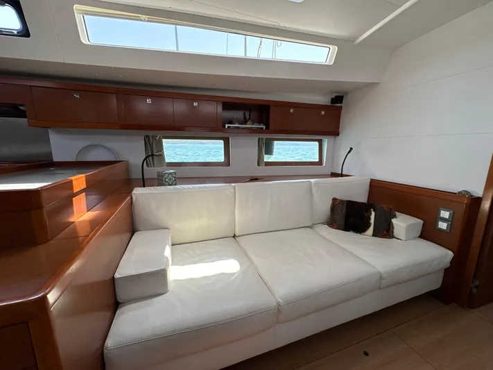Nick Of Time III Yacht Photos Pics Luxurious interior of 2015 Beneteau Oceanis 55 yacht with white sofa and wooden accents.