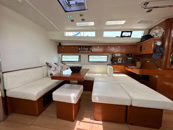 Nick Of Time III Yacht Photos Pics Luxurious interior of 2015 Beneteau Oceanis 55 yacht with white seating and wooden accents.