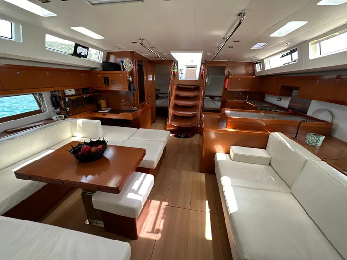 Nick Of Time III Yacht Photos Pics Luxurious interior of 2015 Beneteau Oceanis 55 yacht with elegant wood and white seating.