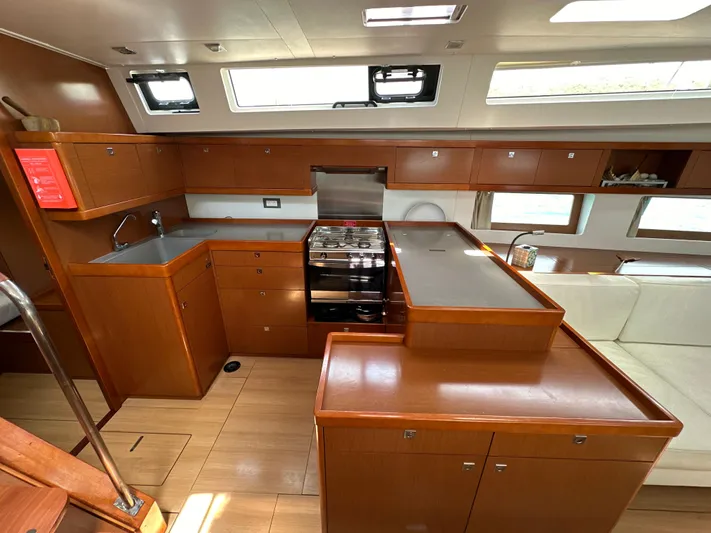 Nick Of Time III Yacht Photos Pics Interior of 2015 Beneteau Oceanis 55 yacht kitchen with wood cabinetry and modern appliances.